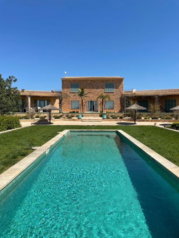 a swimming pool in front of a house at Finca El Idilio in Ses Salines