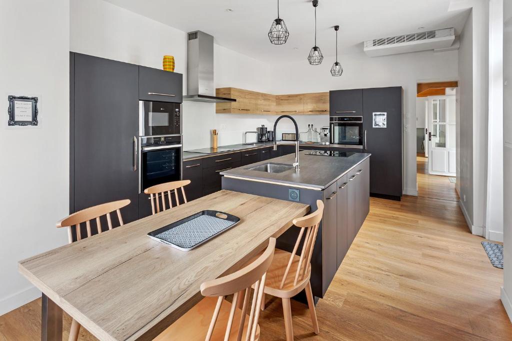 une cuisine avec une table en bois et un évier dans l'établissement Chambres & sde privatives dans maison partagée, à Clisson
