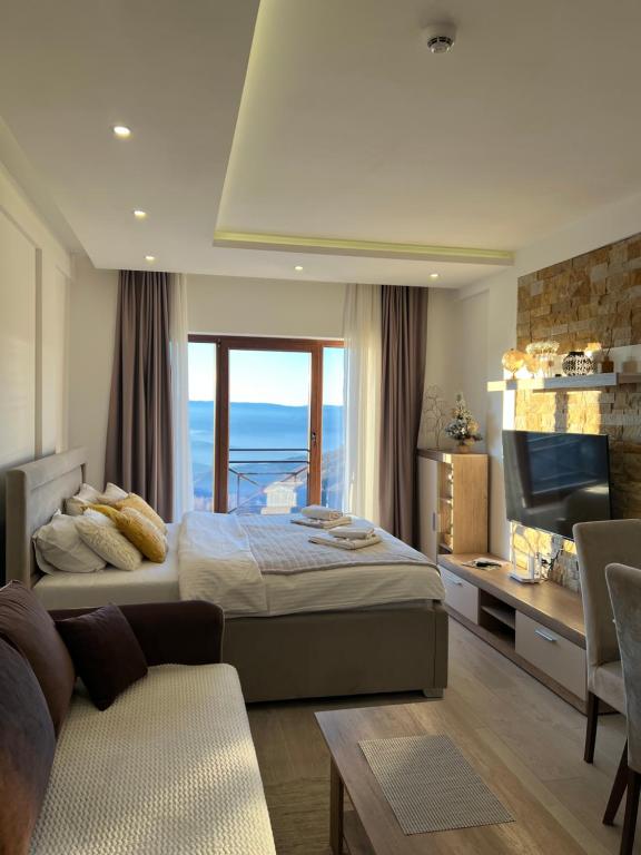 a bedroom with a bed and a tv and a couch at Milmari N69 in Kopaonik