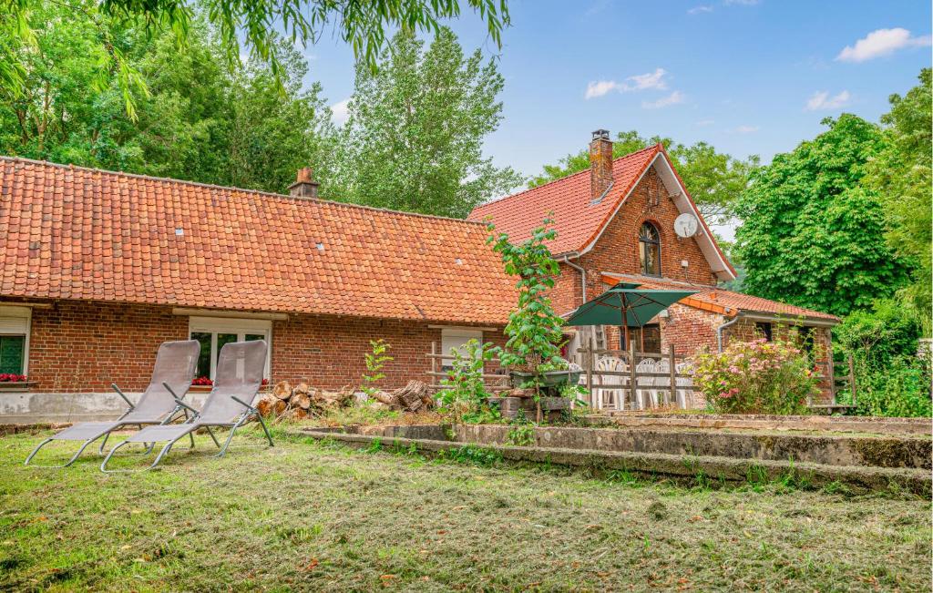een stenen huis met twee stoelen en een paraplu bij Ancien Moulin Restauré in Clerques