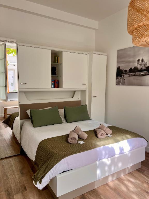a bedroom with a large bed with towels on it at Le Laurencin Sens - Le Parisien - Cœur de ville in Sens