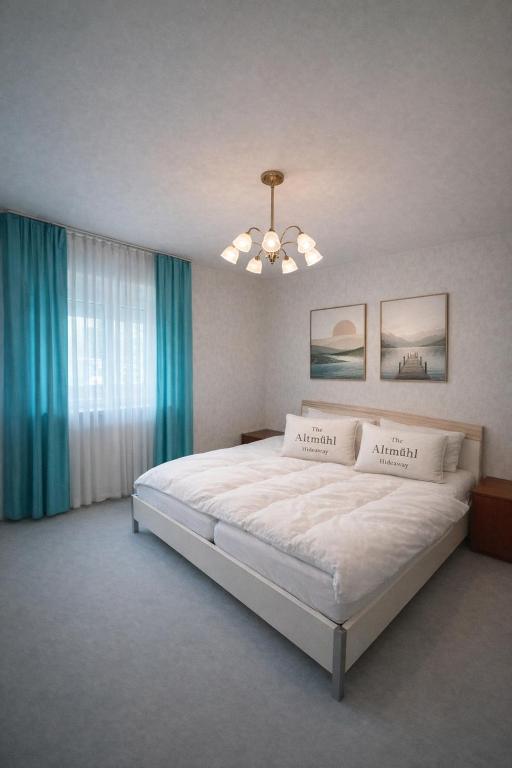 a bedroom with a large white bed and a chandelier at Heumöderntal in Treuchtlingen
