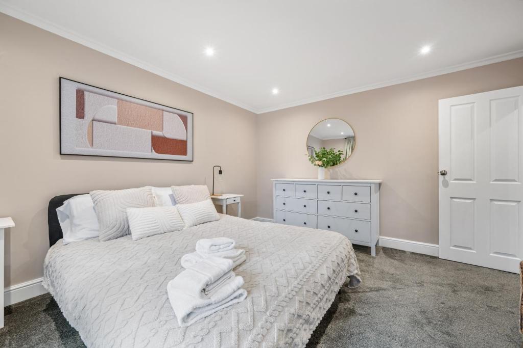 a bedroom with a white bed with towels on it at Lovely Ealing 3 Bed Flat in Ealing