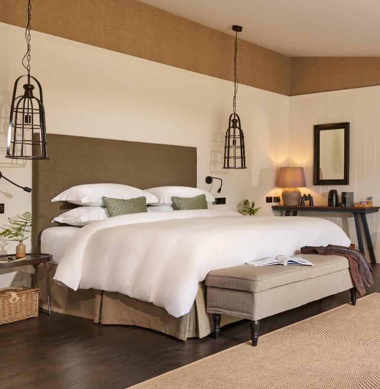 a bedroom with a large white bed and two lights at Dromquinna Manor in Dunkerron Islands