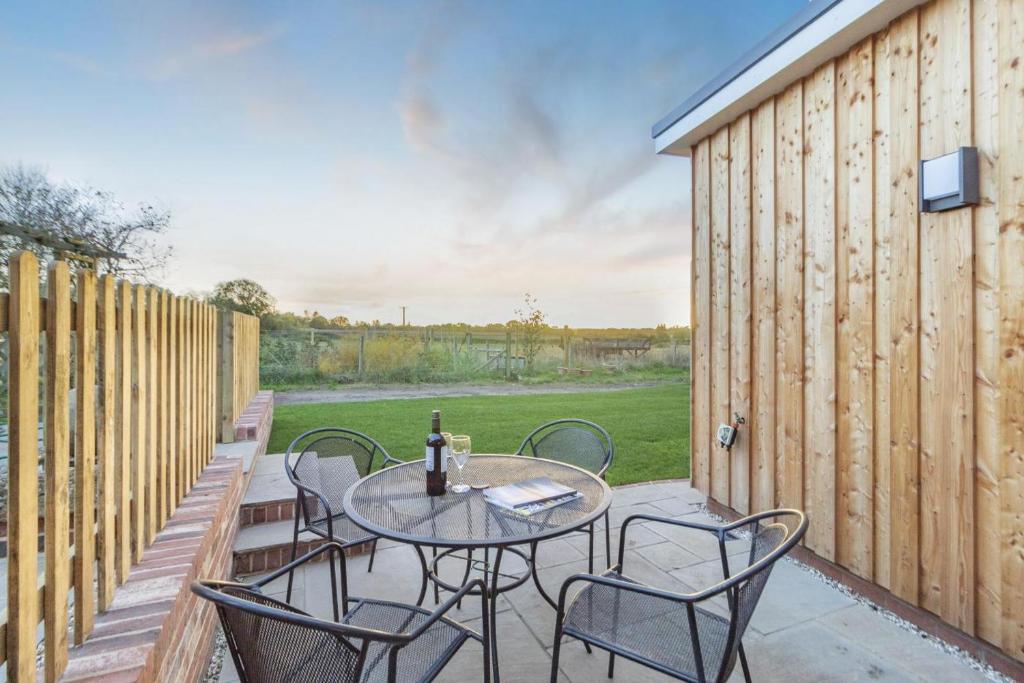 a patio with a table and chairs and a fence at 2 Bed in Snape oc-sfvin in Snape