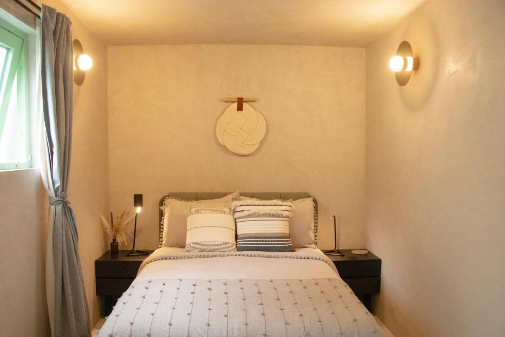 een slaapkamer met een bed en een klok aan de muur bij La Colmena in Mexico-Stad