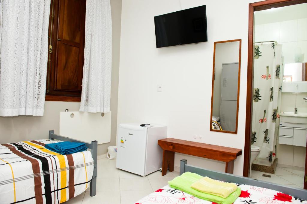 a room with two beds and a mirror at Orange - Casa de Hóspedes - modelo Pousada in Rio de Janeiro