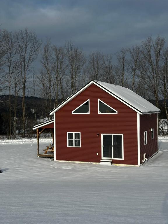 a red barn with snow on the ground at Barn Cottage close to Smugglers Notch in Cambridge