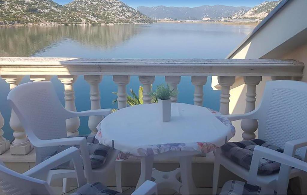 a table and chairs on a balcony with a view of the water at 3 Bedroom Lovely Apartment In Rogotin-Ploce in Rogotin