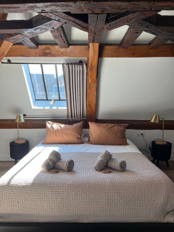 Un dormitorio con una cama grande con dos toallas encima. en Le Laurencin Sens - L Authentique - Cœur de ville, en Sens