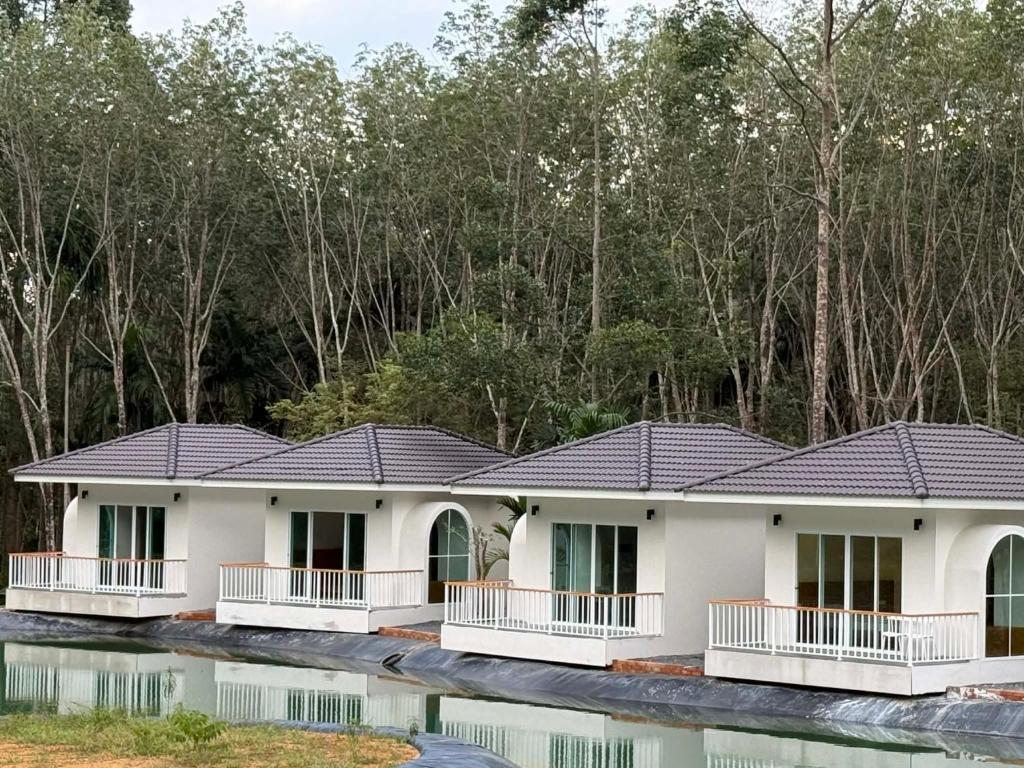 een rij huizen met een reflectie in het water bij Hidden Haven Resort Koh Lanta in Ko Bu Bu