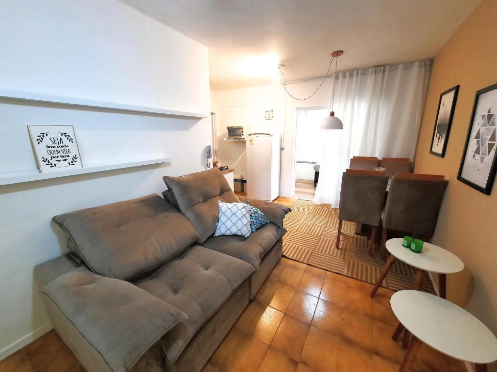 ein Wohnzimmer mit Sofa und Tisch in der Unterkunft Apartamento Centro de Capão da Canoa in Capão da Canoa