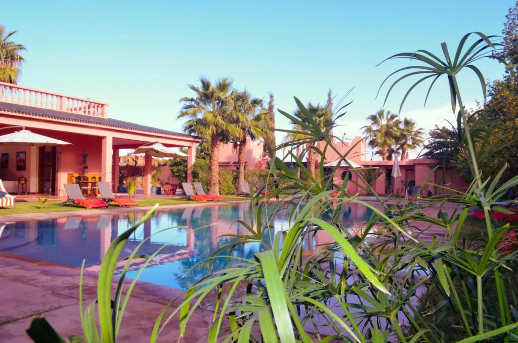 a resort with a swimming pool and palm trees at Villa Essalah & Spa Marrakech in Marrakech