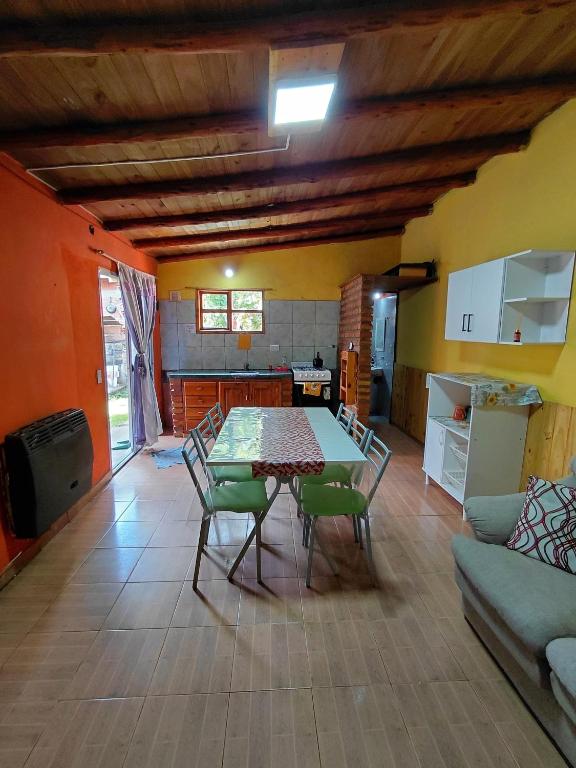 eine Küche und ein Esszimmer mit Tisch und Stühlen in der Unterkunft El Rinconcito in El Bolsón