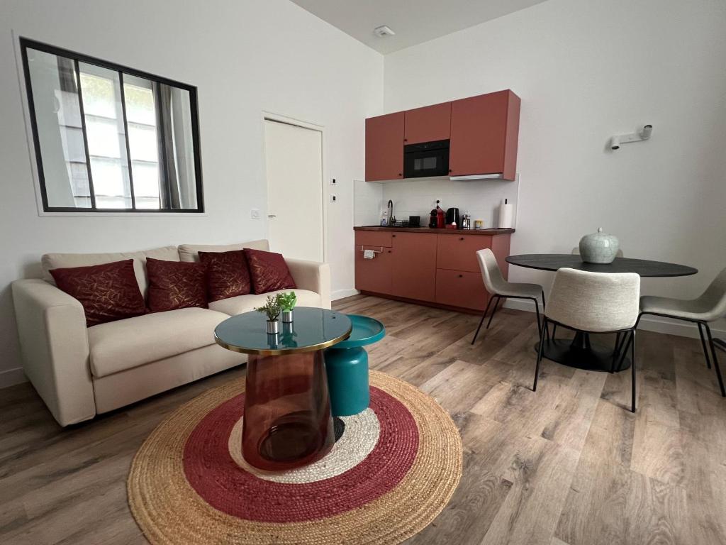 ein Wohnzimmer mit Sofa und Tisch in der Unterkunft Le Laurencin Sens - La Verrière - Cœur de ville in Sens