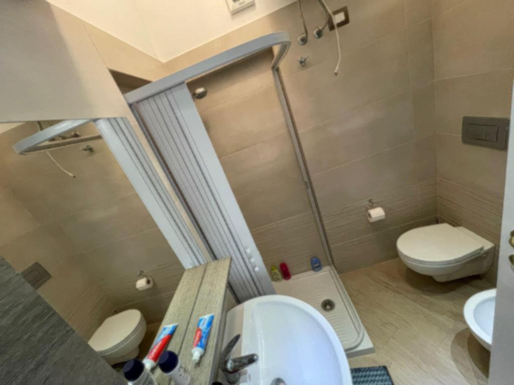 een badkamer met een douche, een toilet en een wastafel bij Casa Emma in Costa Rei