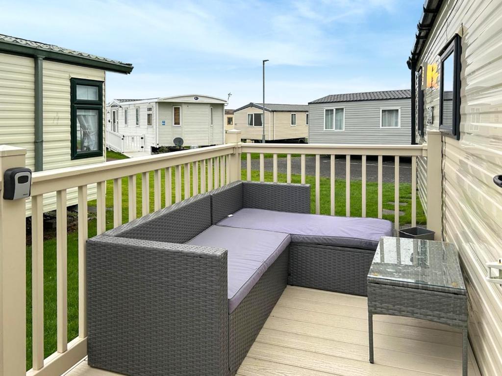 een patio met een bank en een tafel op een balkon bij Ali B's Craig Tara in Ayr