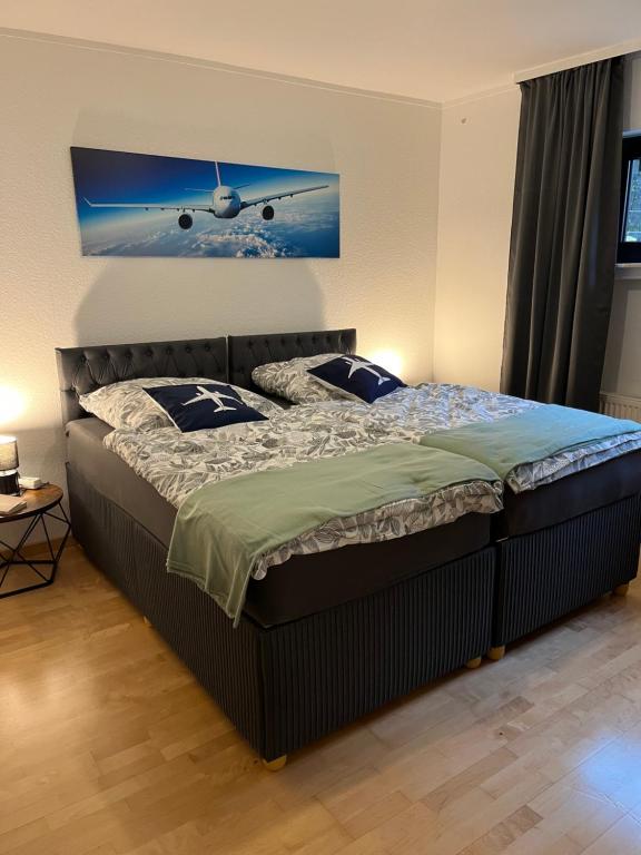 une chambre avec un lit et un tableau d'avion au mur dans l'établissement Gate 18, à Haiger