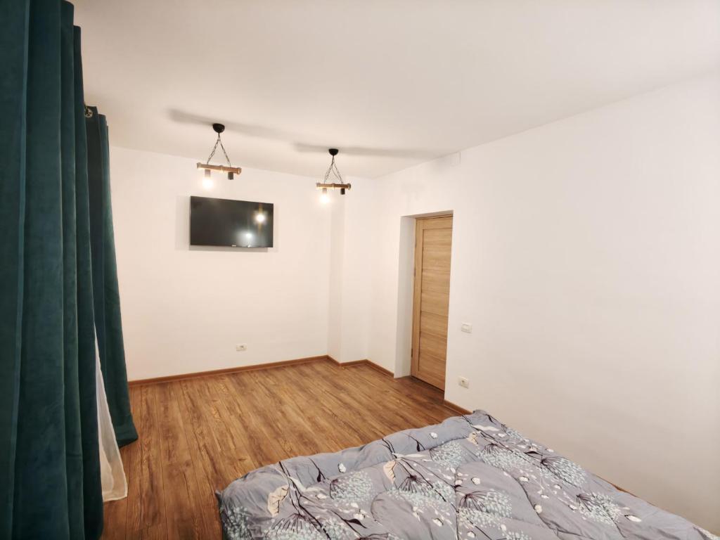 een slaapkamer met een bed en een tv aan de muur bij Studio ultracentral stefan cel mare in Craiova