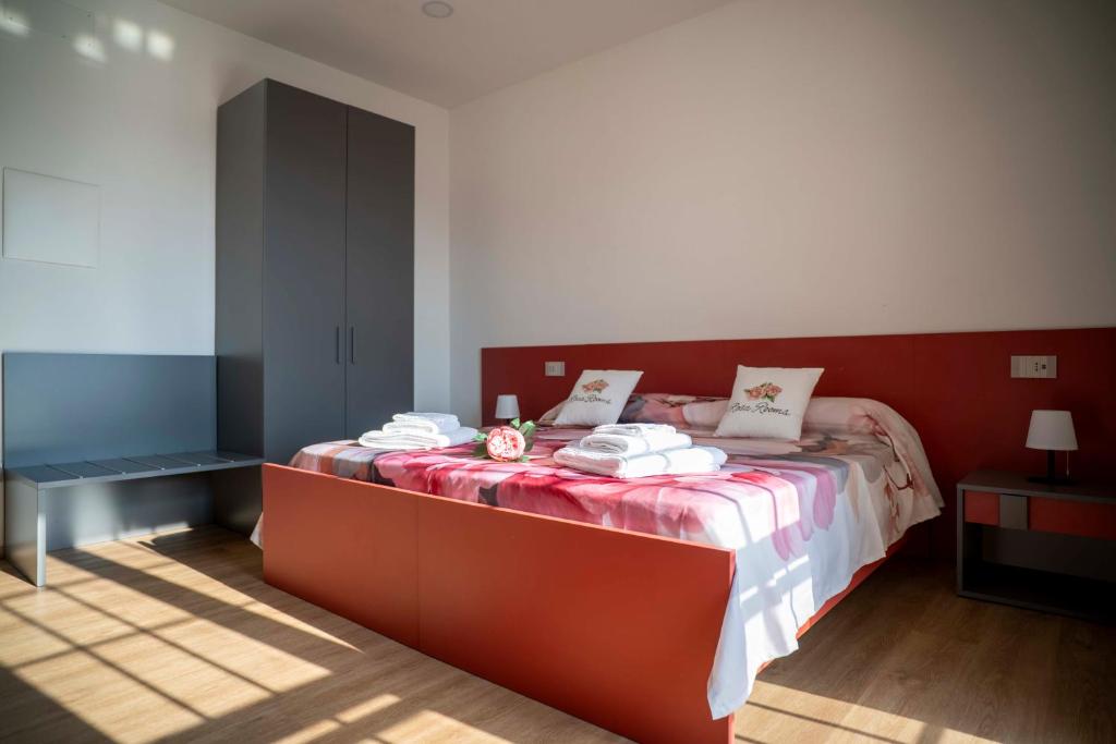 a bedroom with a bed with towels on it at Rosa Rooms Pompei in Pompei