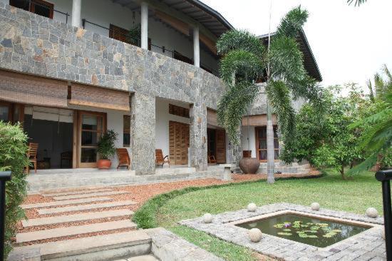 een gebouw met een vijver ervoor bij Mannat in Kandy