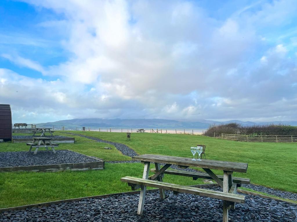 a group of picnic tables in a field with the beach at Meadow - Uk48483 in Dalton in Furness