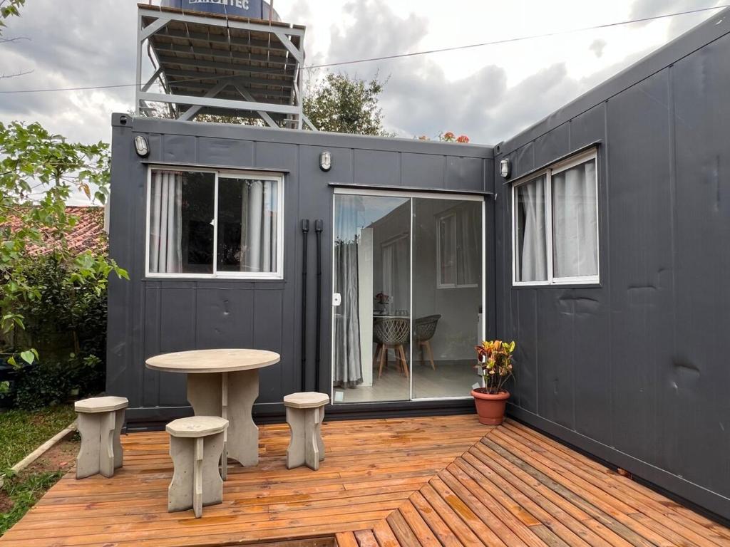 una casetta nera minuscola con ponte di legno di Containers Schmitz - Kitnet 1 a Florianópolis