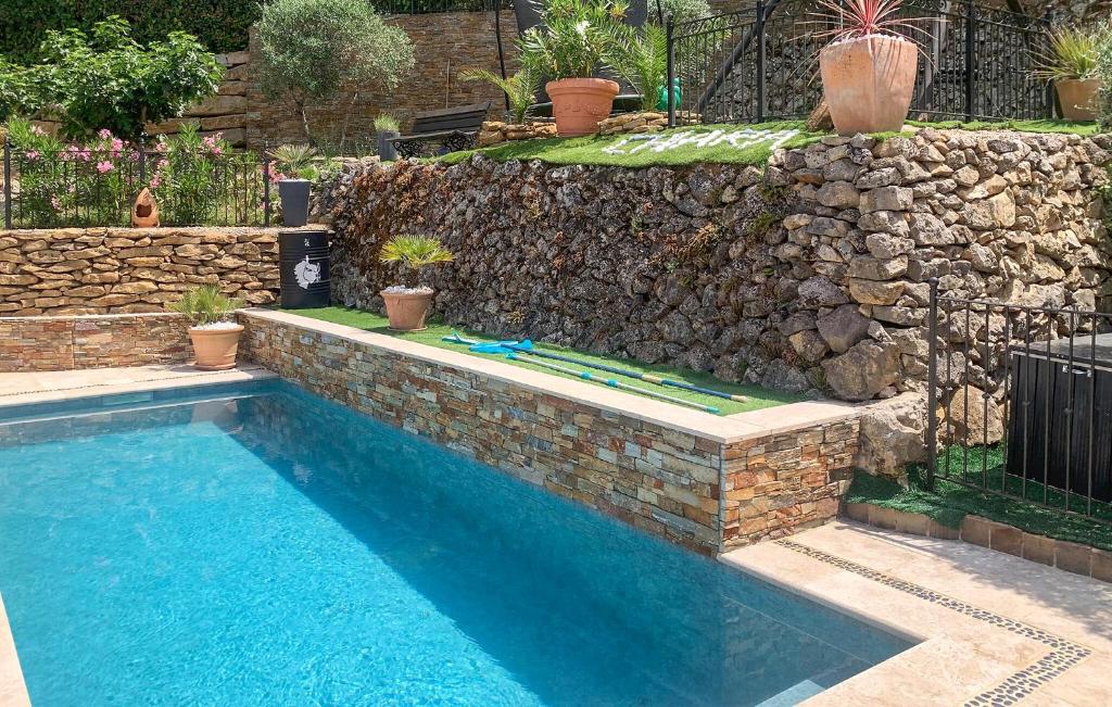 - une piscine en face d'un mur en pierre dans l'établissement Maison Avec Piscine, à Gémenos