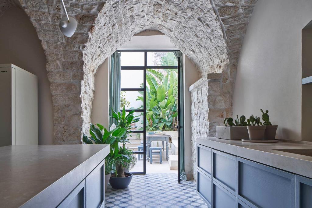 een keuken met een boog en een aanrecht met planten bij Dimora Cocchi in Carovigno