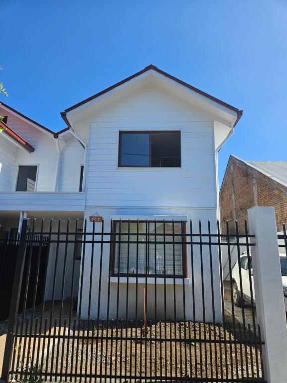 a white house with a black fence at Casa con estacionamiento privado in San Carlos