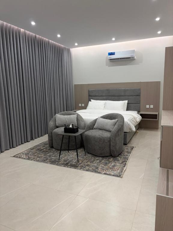 une chambre avec un lit, deux chaises et une table dans l'établissement luxury royal apartments, à Quai