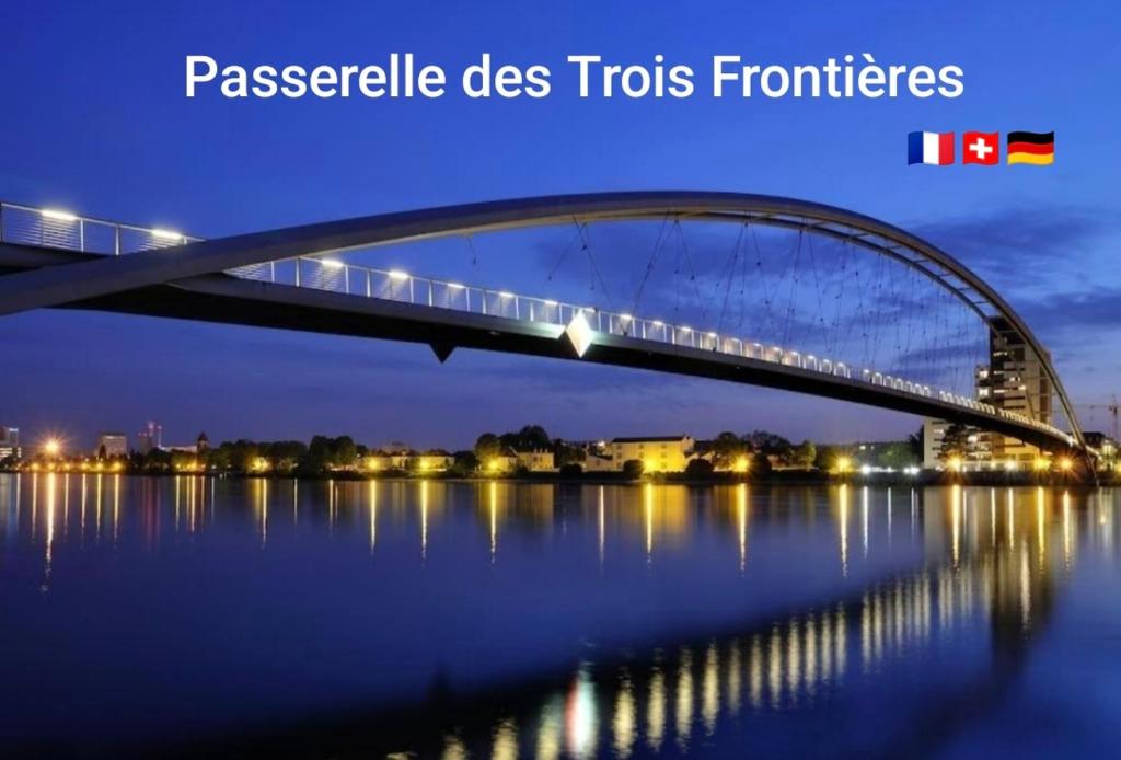 a bridge over the water at night at Studio des Trois Frontières in Saint-Louis