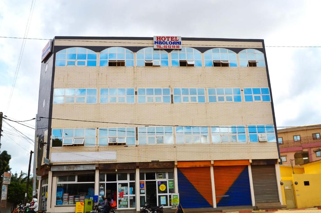 Un edificio con un cartel encima en Hotel Mboloani, en Lomé