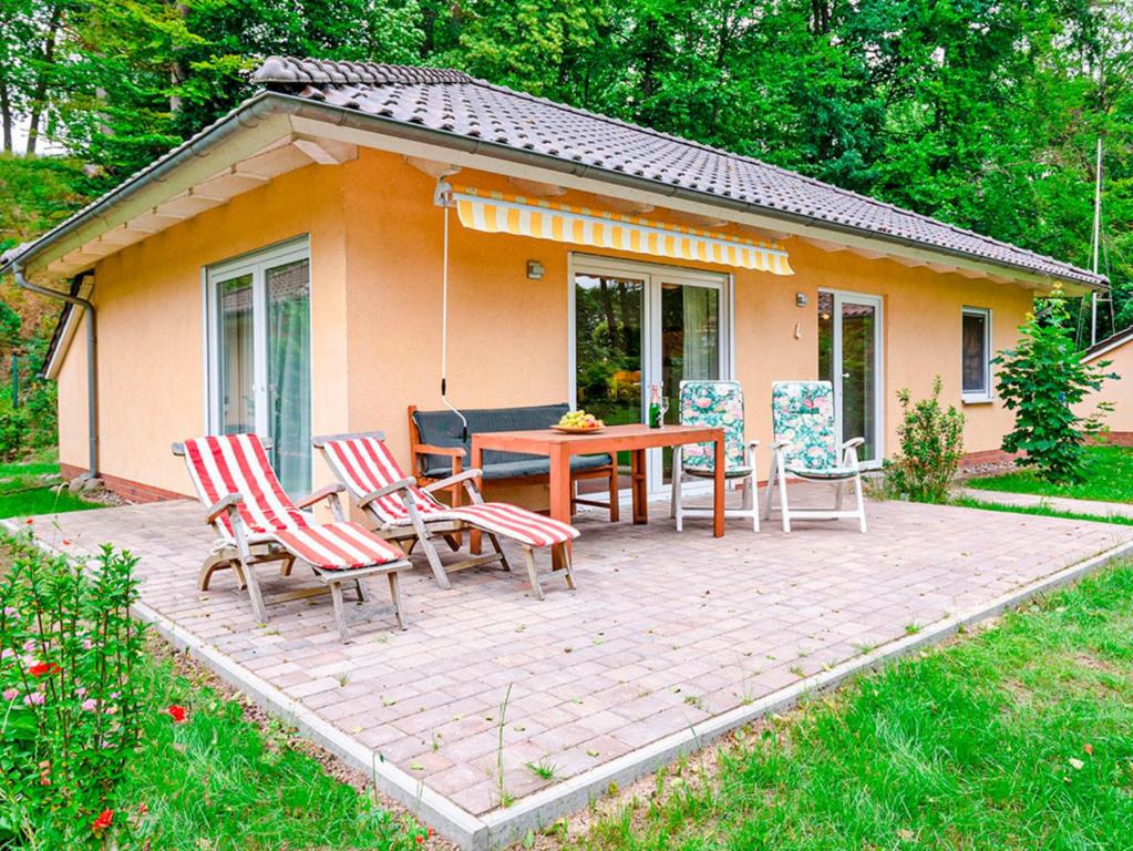 a patio with a table and chairs in front of a house at Ferienhaus Lenz am Plauer See in Lenz