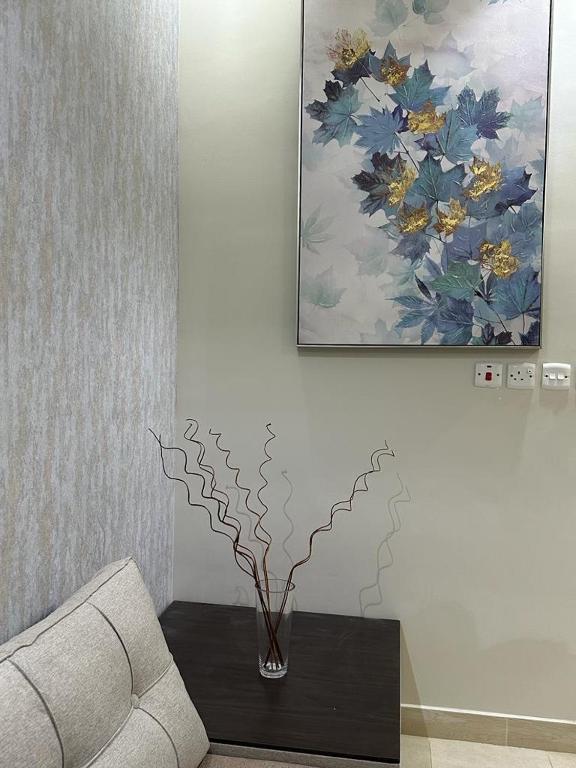a living room with a couch and a vase on a table at شقق واجنجة سمو بالعلا in Al-ʿUla