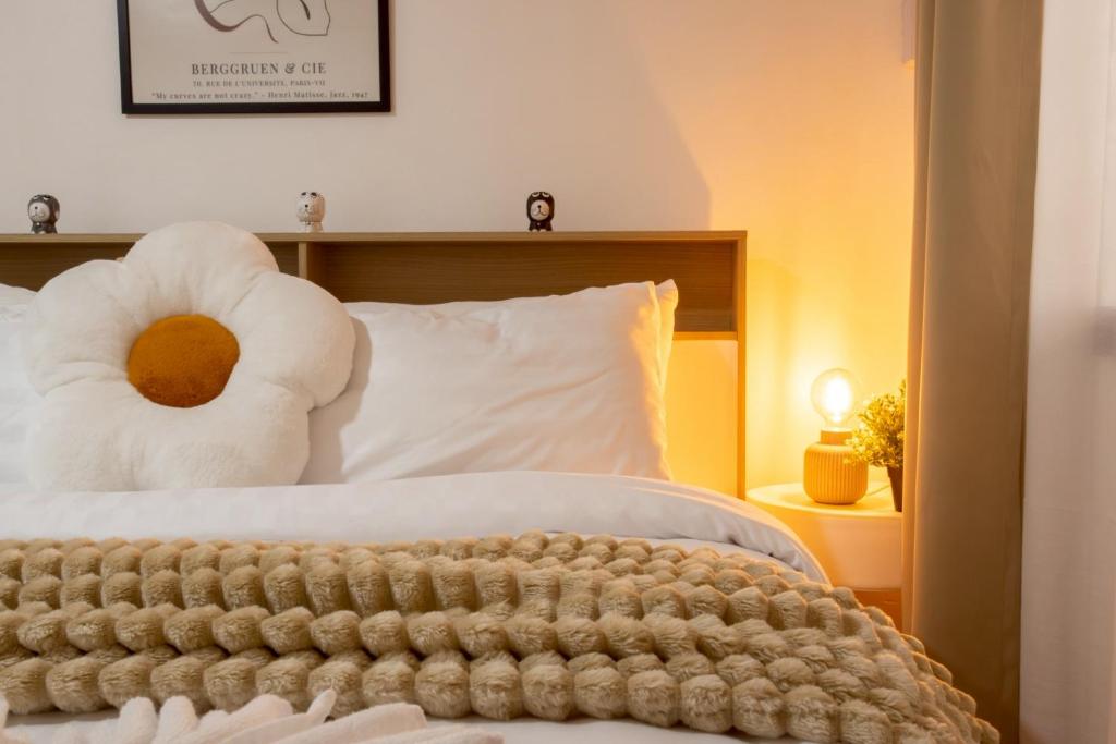 een bed met een knuffeldier erop bij Cosy Lodge MRT Phra Ram 9 in Bangkok