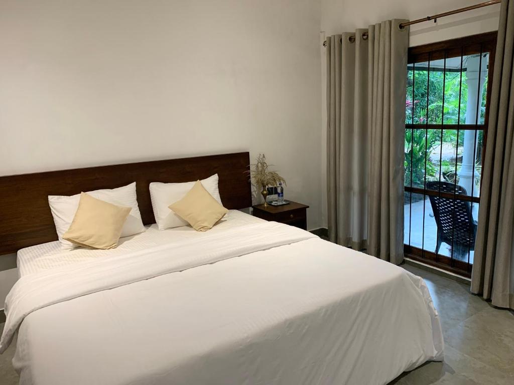 En eller flere senge i et værelse på Elephant Trail Homestay