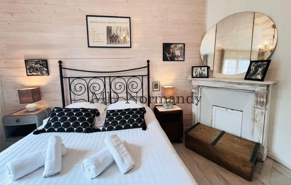 een slaapkamer met een groot bed en een spiegel bij Belle Maison centre Villerville - 8 personnes - Terrasse in Villerville