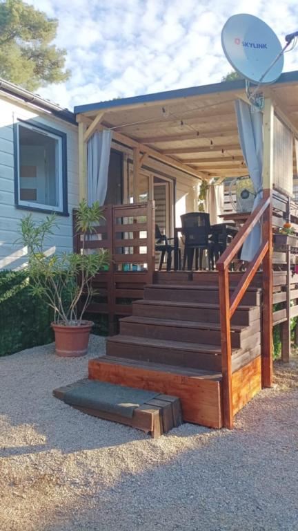 a house with a wooden deck with a patio at Mobil home Katka in Biograd na Moru