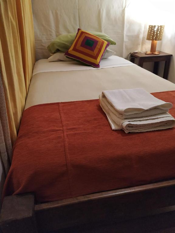 1 cama con 2 toallas plegables encima en Casa Suyay, en Tilcara