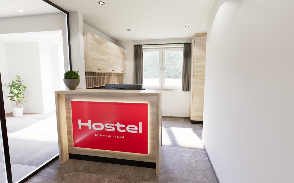 una hall di un ostello con un cartello rosso sul bancone di Hostel Maria Alm a Maria Alm am Steinernen Meer
