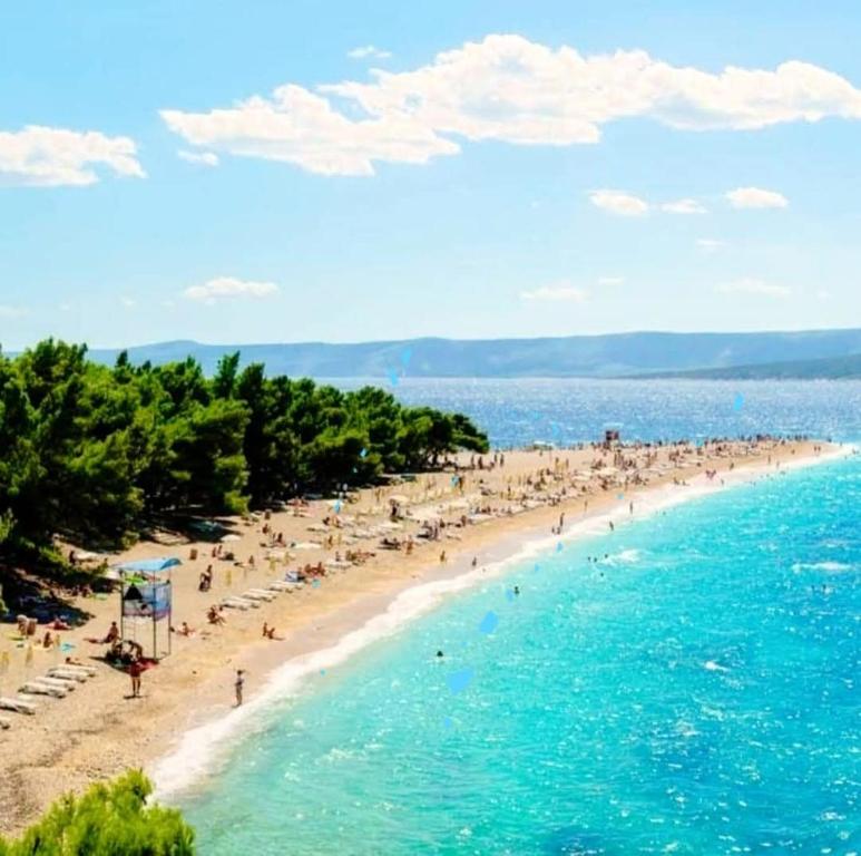 a beach with a lot of people in the water at Bol apartments Gospojica in Bol