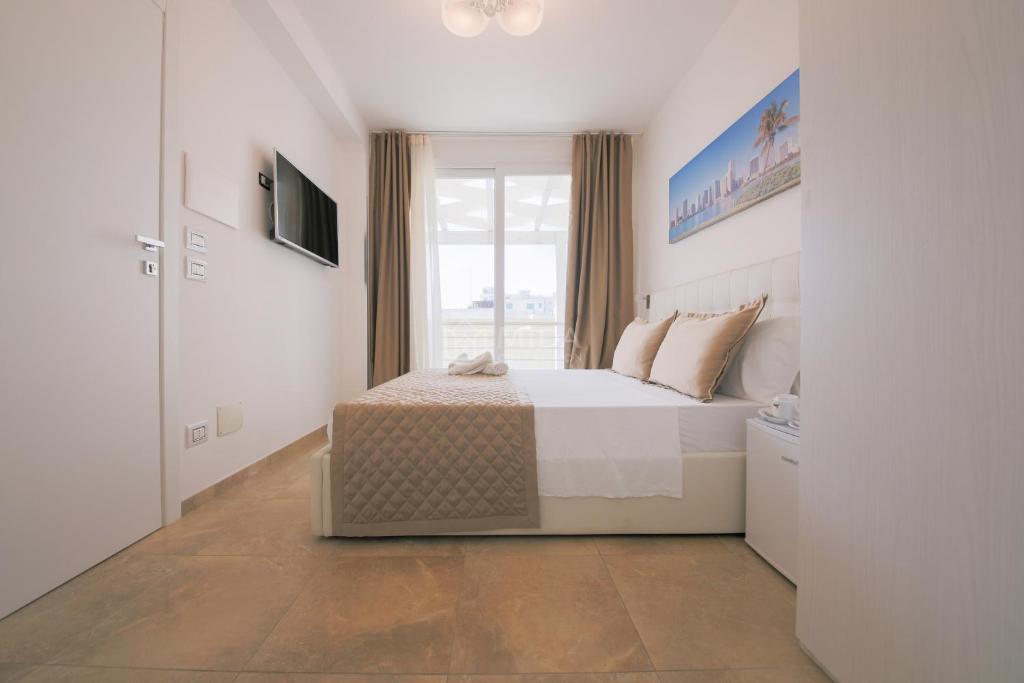 a bedroom with a bed and a window at Artemar in Porto Cesareo