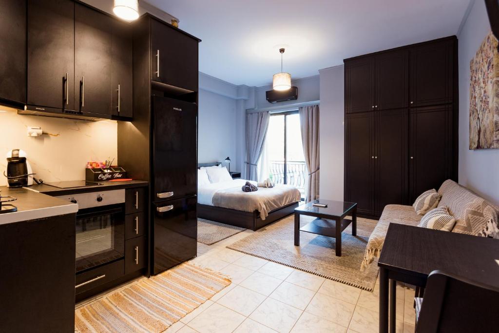 a kitchen and living room with a couch and a bed at Nero Apartment in Agrinion