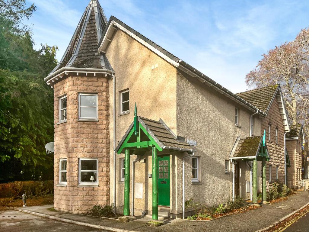 an old brick house with a green door at Dee View Apartment in Banchory