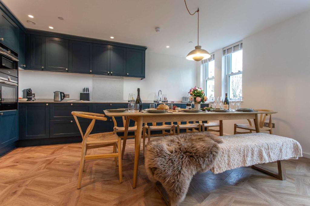 a kitchen with a wooden table with chairs and a dining room at St James Central Splendor in Bath
