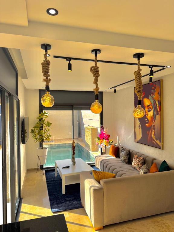 a living room with a couch and a table at Villa 2 Évasion Urbaine, 3 Chambres, à 20 min de Rabat in Sidi Yahia az Zaʼer