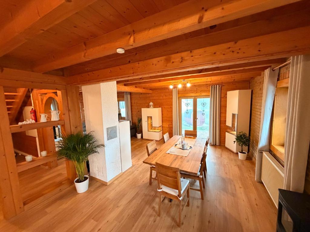 een houten eetkamer met een tafel en stoelen bij Ferienparadies Vogelsbergliebe in Grebenhain