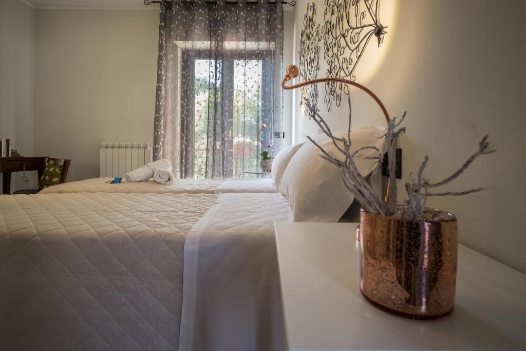 a bedroom with a bed and a vase with branches in it at Geo House in Termoli