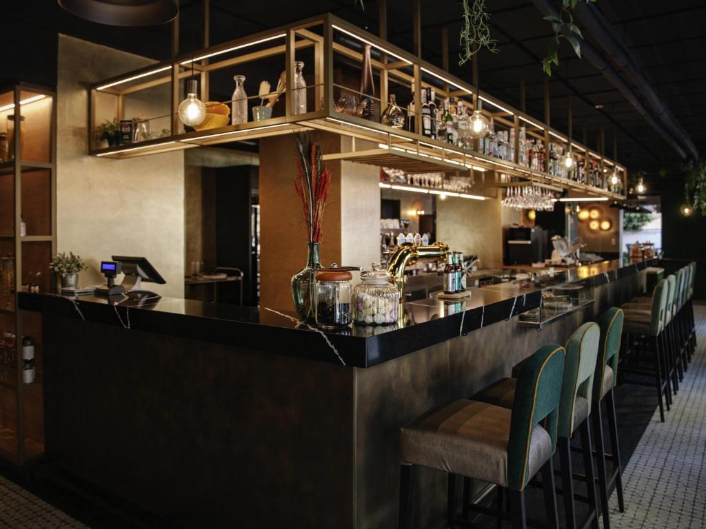 um bar com um balcão longo com cadeiras em Hotel Mercure Roma Corso Trieste em Roma